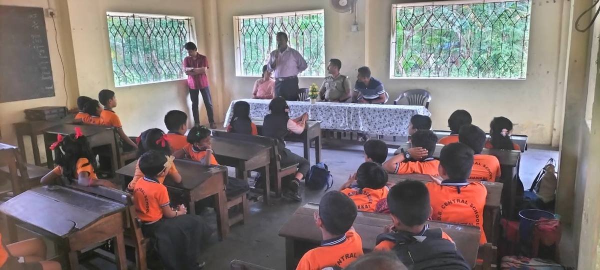 A speaker addressing the class, the panel of guests seated at the table behind him.
