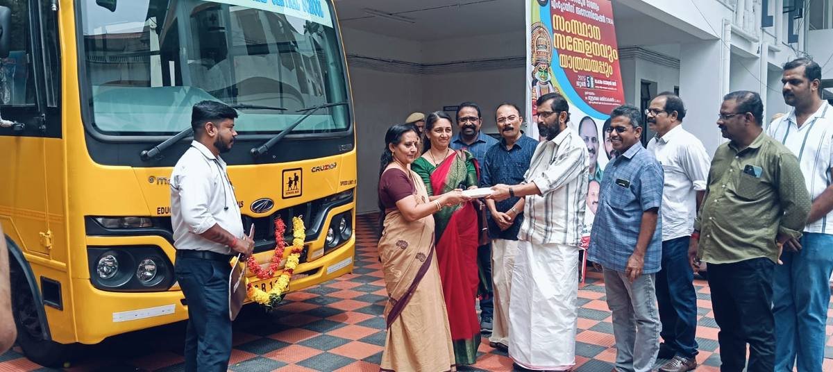 The bus papers being handed over in front of the vehicle, a line of guests looking on.