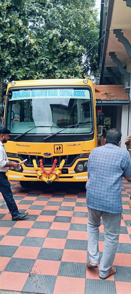 The bus head-on with a marigold garland across its bumper.