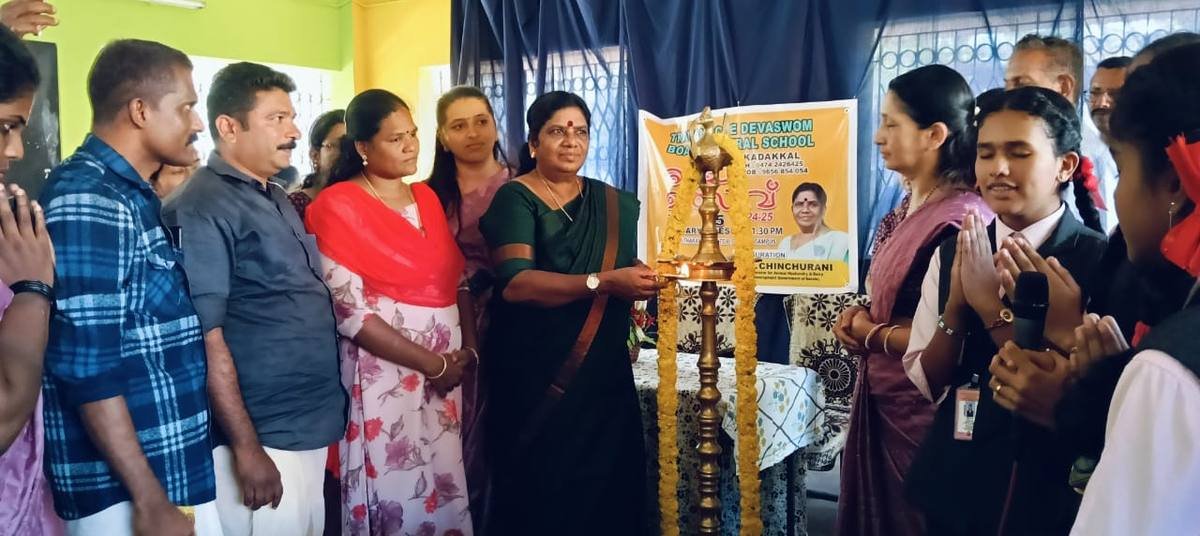 A guest touching the flame to the garlanded lamp beneath the fest banner.