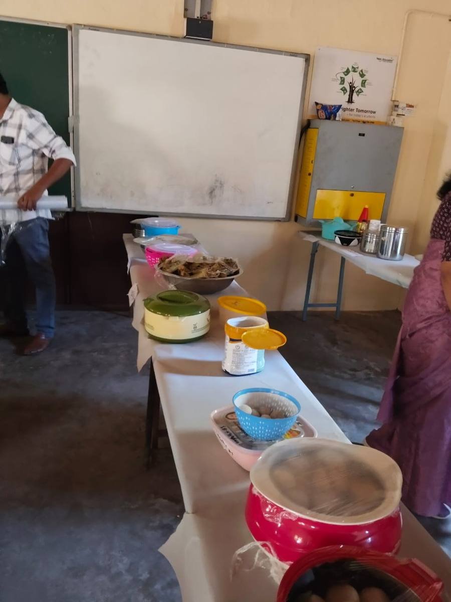 Bowls, tins and boxes of food ranged along the tables against the classroom wall.