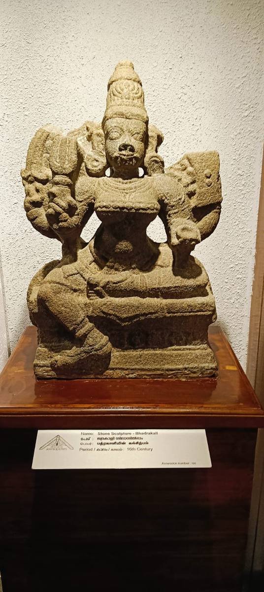 A weathered stone sculpture of Bhadrakali on a plinth in the palace museum, its label giving the period as the sixteenth century.