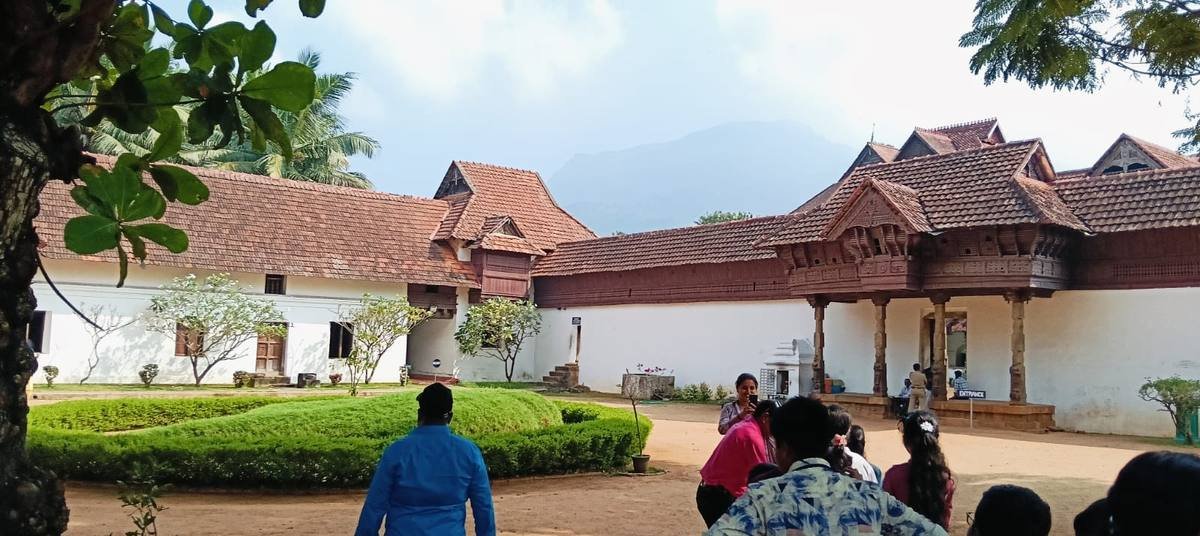 The palace courtyard with hills rising in the haze behind it.