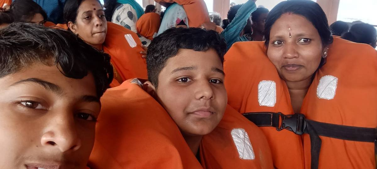 Pupils and teachers in orange life jackets aboard the ferry.