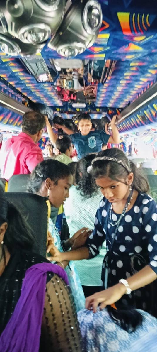 Inside the tour bus, pupils standing in the aisle among the seats.